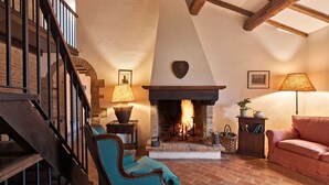 A cozy living room with a fireplace, a staircase, and a comfortable seating area. - HAMLET THE POET - LODGE HOUSE (Umbria)