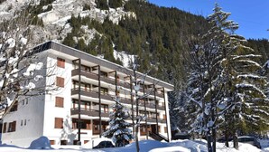 Un hôtel moderne à plusieurs étages, doté de balcons et situé dans un cadre montagneux.