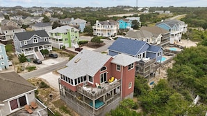 Un quartier résidentiel situé sur la côte, avec des maisons dotées de balcons, d’une piscine et offrant une vue sur la plage.