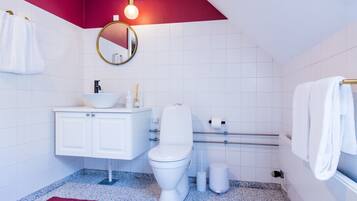 A modern bathroom with a white sink, toilet, and vanity.