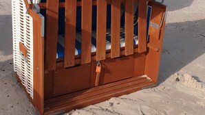 A wooden beach chair with a white canopy labeled "WANGERLAND Nordsee" and "WANGERLAND.DE".
