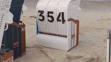 Relax on the beach with comfortable chairs and a convenient signpost.