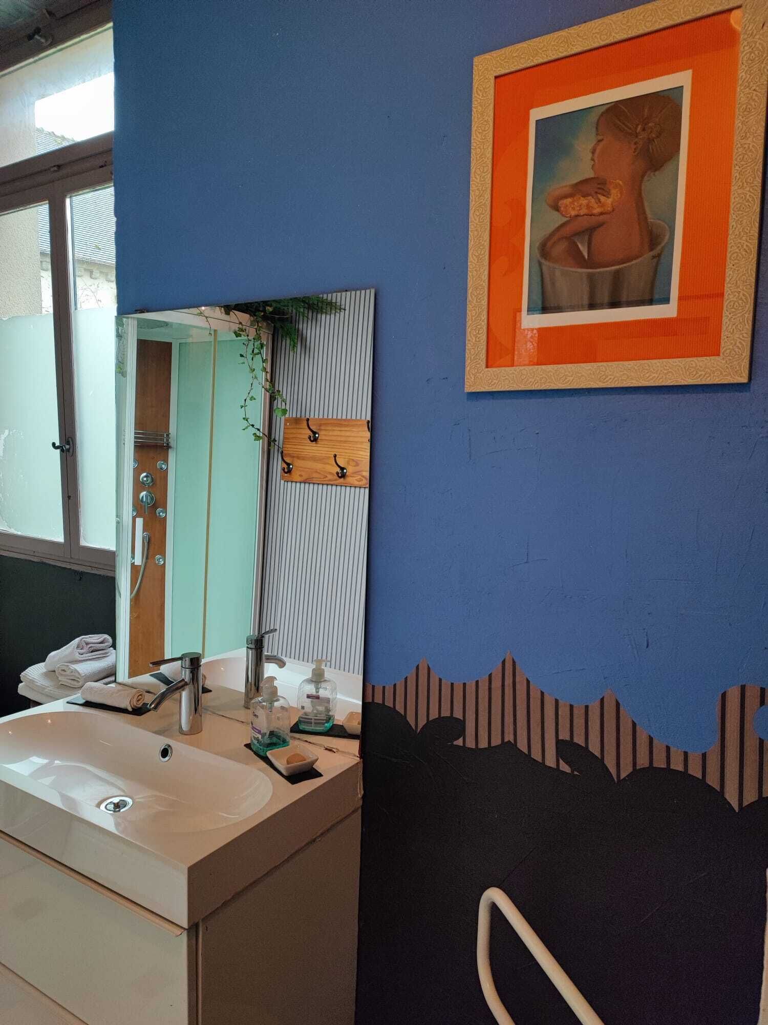 A bathroom with a sink, mirror, and towel rack.