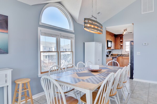 Enjoy meals in this spacious dining area with a large table, high ceiling, and stunning views.