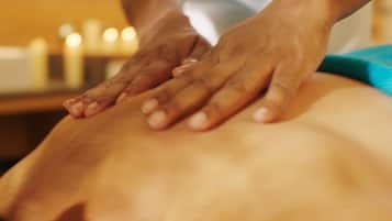 A close-up of hands performing a massage on a person's back.