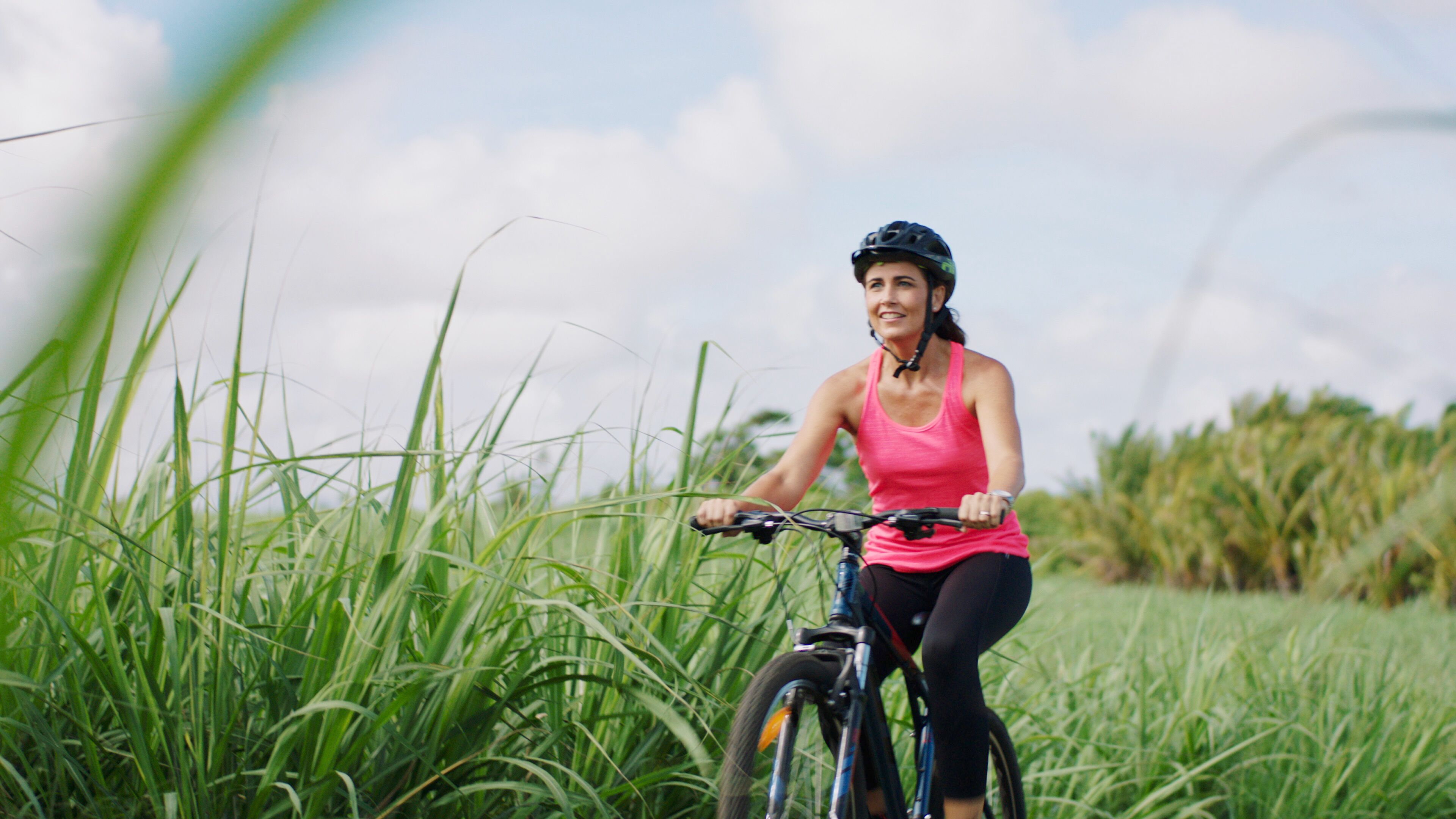 A person riding a bicycle in a grassy field.