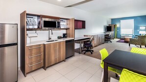 Una cocina moderna con electrodomésticos de acero inoxidable, armarios de madera y un comedor con mesa y sillas.