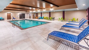 Zona de piscina con sillas de descanso, vestuarios y una recepción.