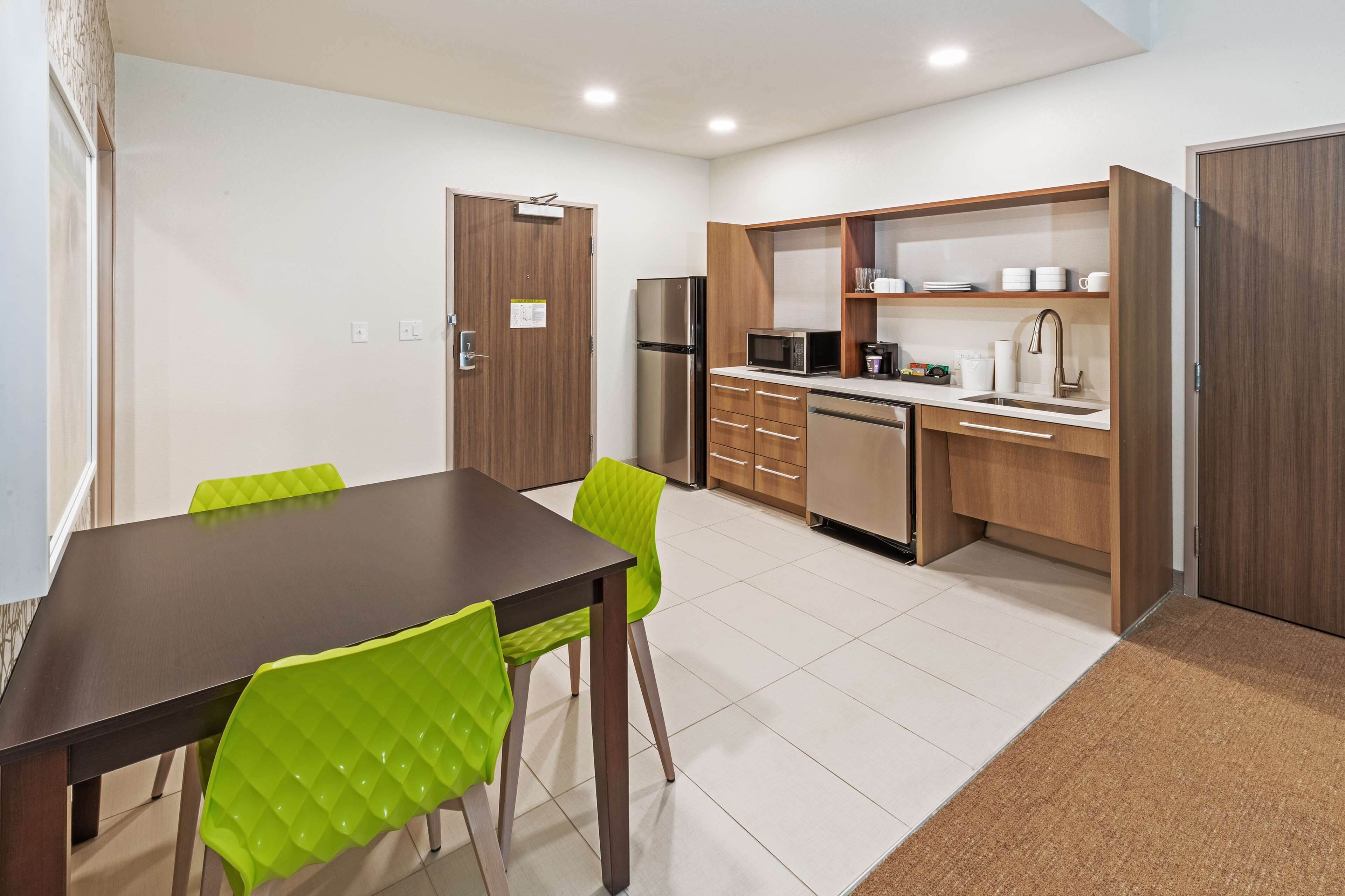 A modern kitchen with a dining area, including a table, chairs, and built-in appliances.