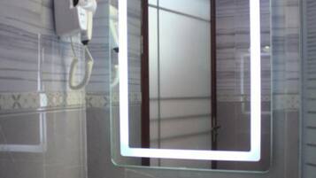 Tina con regadera, pantuflas, toallas