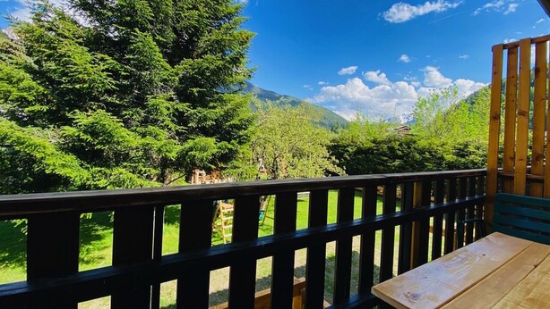 Eine Holzterrasse mit Blick auf eine gebirgige Landschaft.