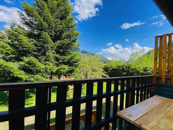 Eine Holzterrasse mit Blick auf eine gebirgige Landschaft.
