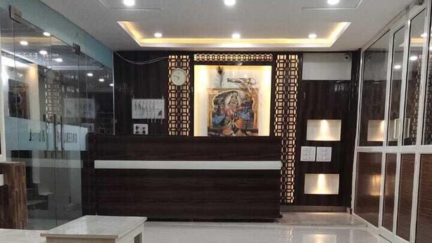 A spacious lobby with a reception desk, seating area, and a large wall mural. - Green Leaf (Jhansi)