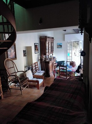 A cozy living room with a wooden staircase, a large wooden cabinet, and a sofa.