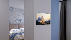 Ein Schlafzimmer mit einem Bett, einem Blattmuster an der Kopfteil und einem Bild an der Wand.