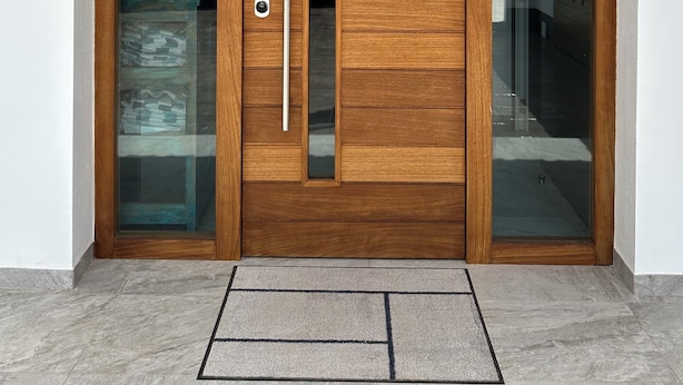 Een houten voordeur met een ruit en een verticale deurklink.