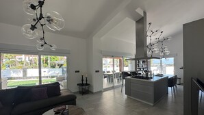 Een ruime woonkamer met een bank, salontafel en een keukeneiland.
