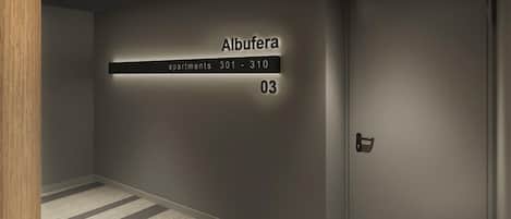 A hallway with a sign indicating 'Albufera apartments 301-310' and the number '03'.