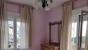 A bedroom with a bed, a wooden dresser, a mirror, and a window with curtains. - Casa Rubén Darío, located in the Sierra de Gredos (suitable for pets) (Villarejo del Valle)