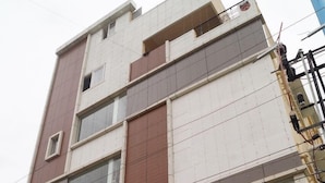 A multi-story building with a sign for "S.S.K. DELUXE HOTEL & LODGE" indicating it is a family restaurant and attached bar. - BSK Deluxe Lodging (Bengaluru)
