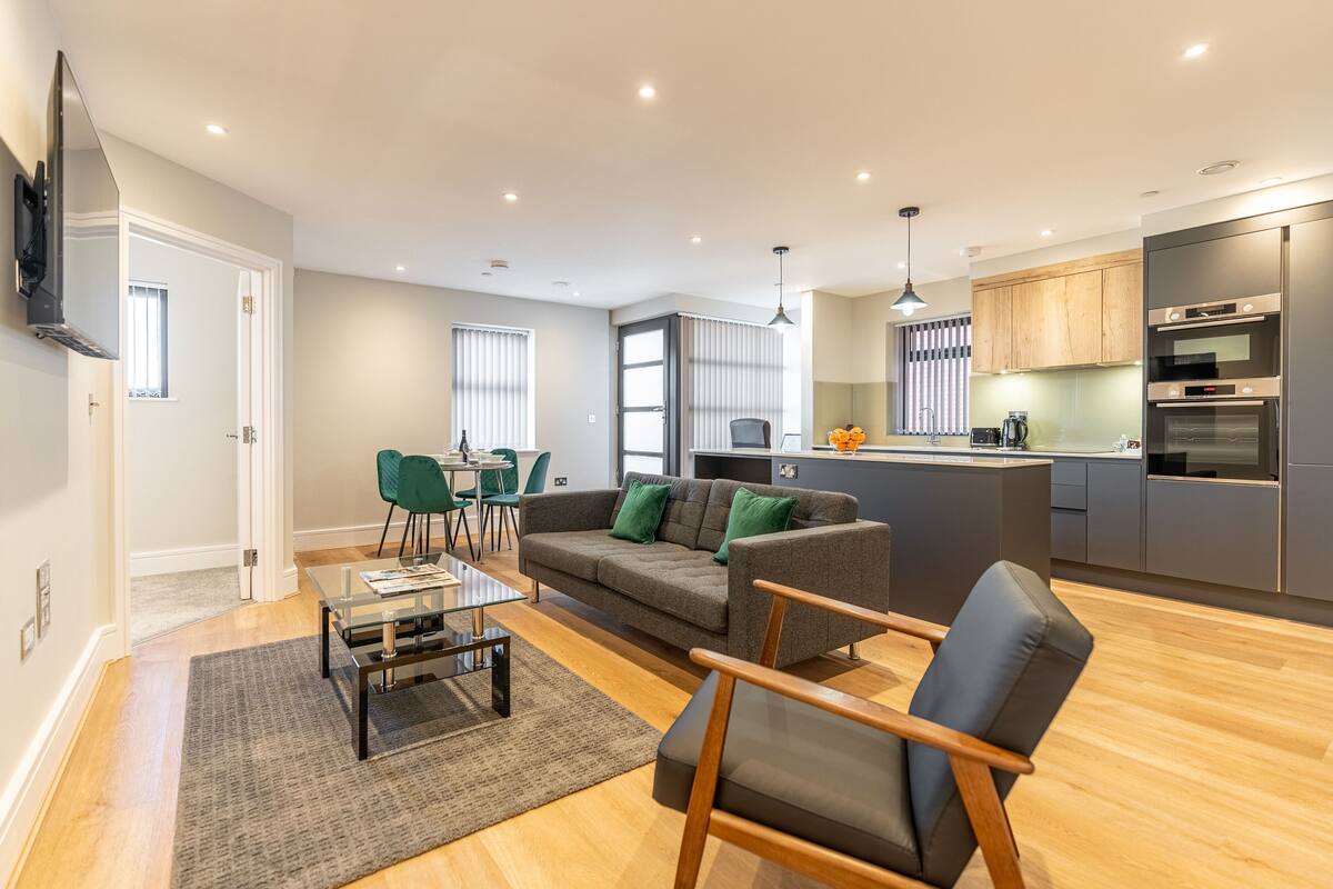 A modern apartment with a living room, dining area, and kitchen.