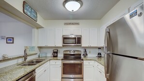 A modern kitchen with stainless steel appliances, white cabinets, and granite countertops. - 2 BR Treetops First Floor easy to access Bikes & Beach Gear included (Hilton Head Island)