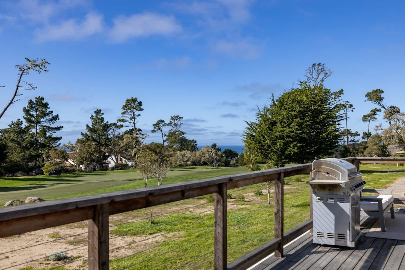 Una terraza con una parrilla asadora con vista a un campo de golf.