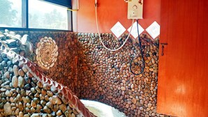 Una habitación con pared de piedra, una ventana y un calentador de agua instalado en la pared.