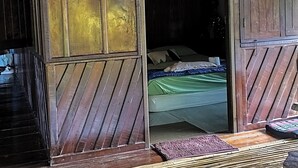 Una habitación con una cama, una puerta de madera y un felpudo en el suelo.