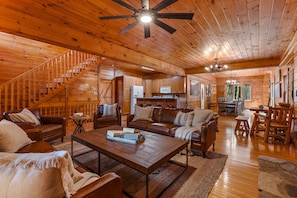 Ein geräumiges Holzhaus-Interieur mit Treppe, Wohnzimmer, Küche und Essbereich.