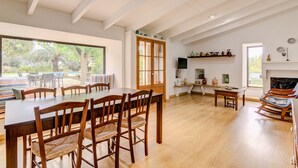 A spacious dining area with a large wooden table and chairs, a wooden ceiling, and a view of the outdoors. - Can Garbeta by Rentallorca (Manacor)