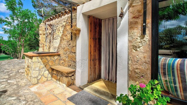 A stone exterior with a wooden door and a bench. - Can Garbeta by Rentallorca (Manacor)