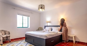 A bedroom with a bed, a window, a lamp, and a chair. - Porto Tranquilo in Porto Martins (Praia da Vitoria)