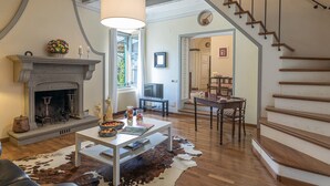 A living room with a fireplace, a dining area with a table and chairs, and a staircase. - Casa Ciculino 8 (Monteleone d'Orvieto)