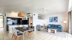 A modern apartment with a kitchen, dining area, and living room.