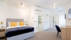 A modern hotel room with a large bed, a desk, and a wardrobe. - Interlude House by City Living London (London)