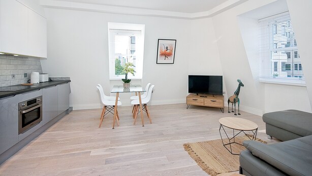 A modern living space with a kitchen, dining area, and seating area. - Interlude House by City Living London (London)