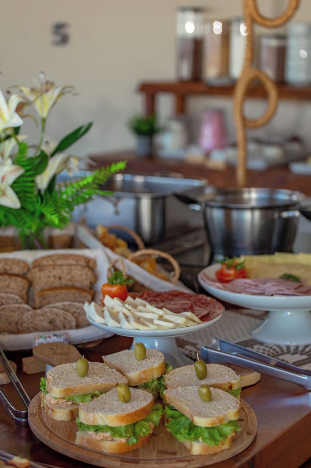 Una mesa de buffet con sándwiches, pan y diferentes acompañamientos.