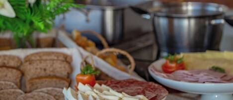 Una mesa de buffet con sándwiches, pan y diferentes acompañamientos.