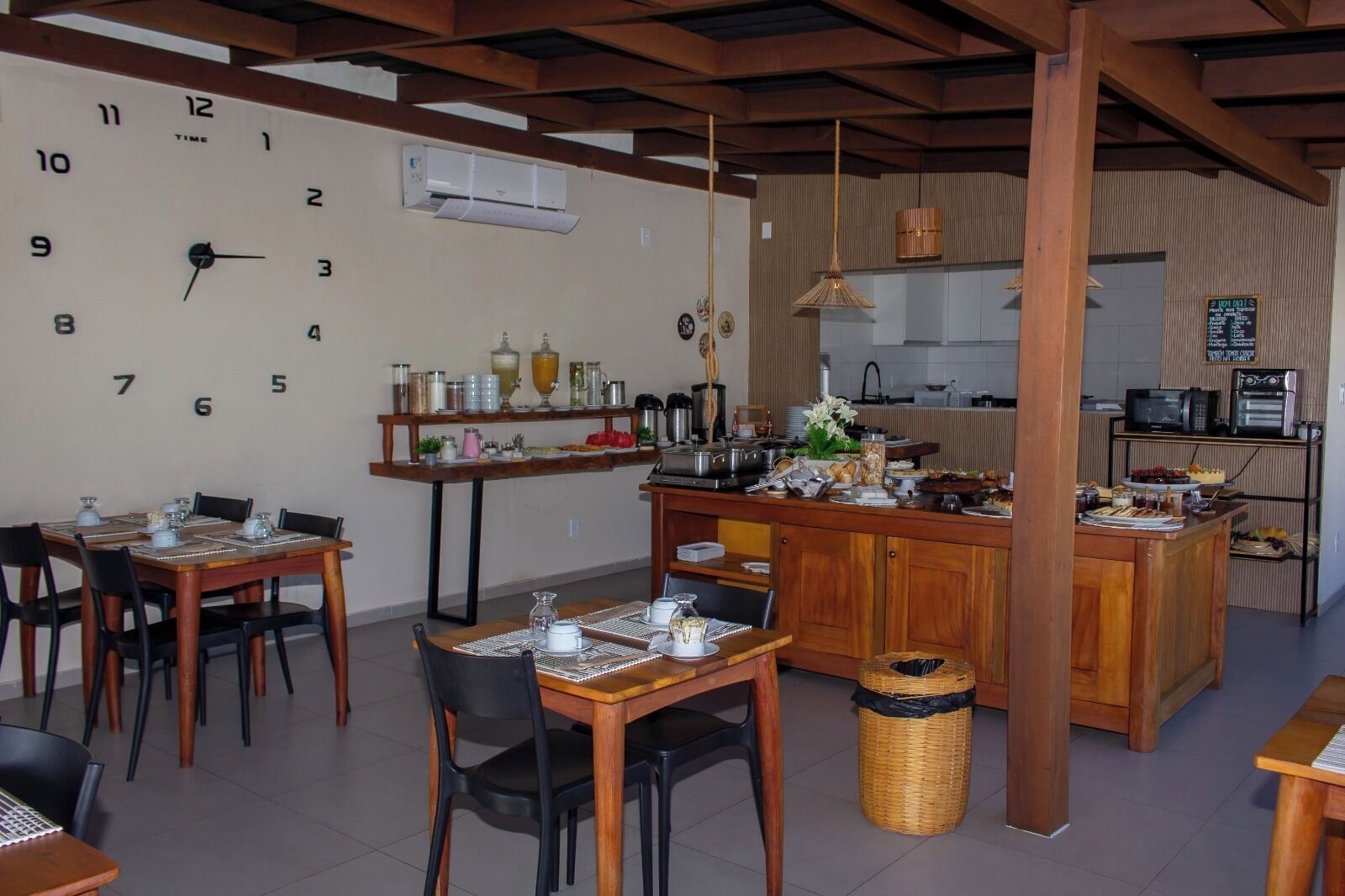 Un comedor con un reloj, una cocina y una barra.
