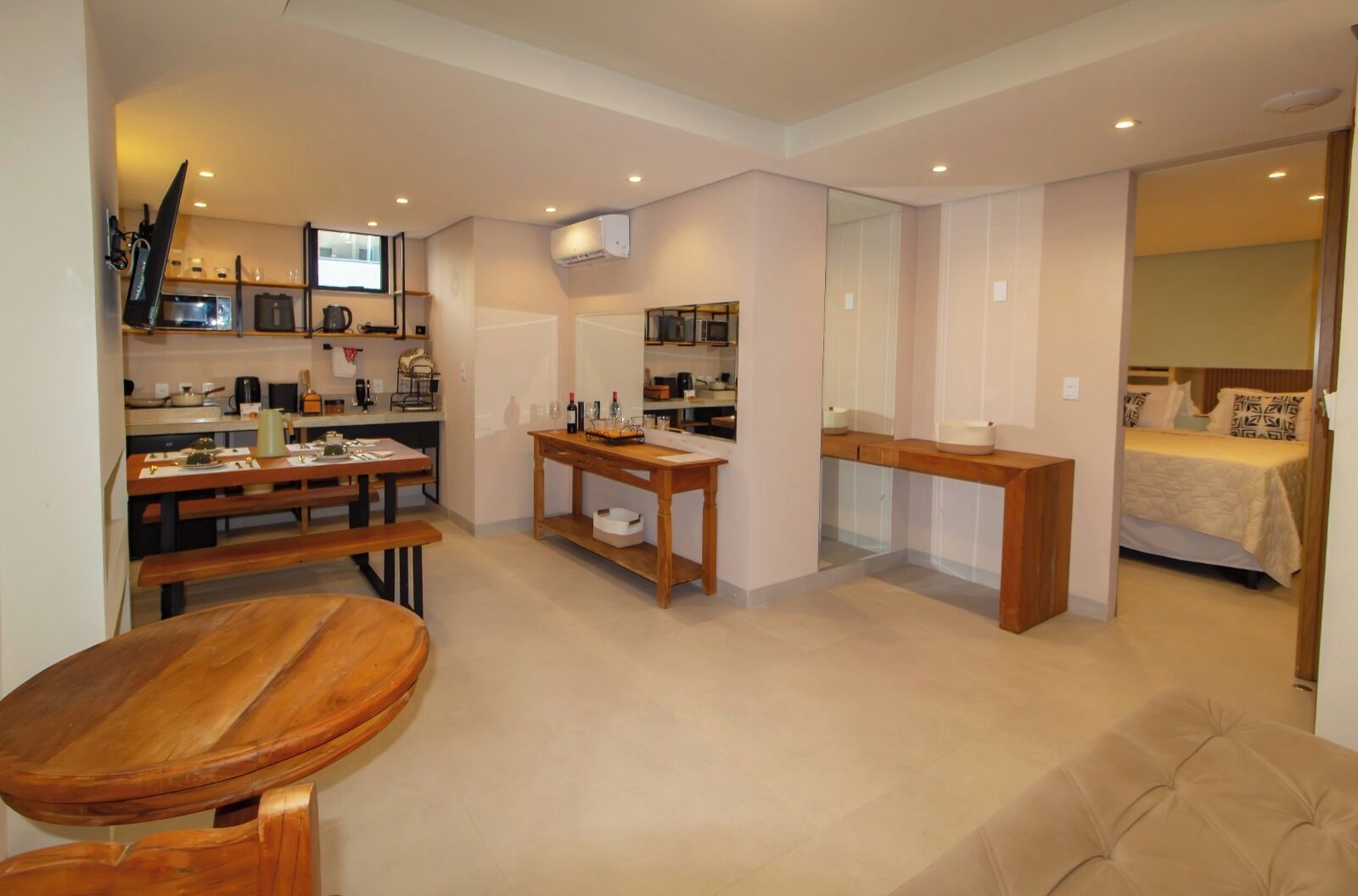 A compact living space with a kitchenette, a dining area, and a bedroom.