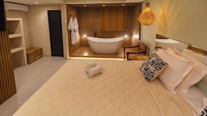 A modern bedroom with a large bed, a built-in bathtub, and a wooden vanity. - Terra Bella Pousada (Cairu)
