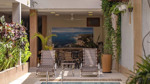 A pool area with seating, a staircase, and indoor plants. - Terra Bella Pousada (Cairu)