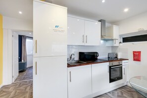 Kitchen equipped with a stainless steel sink, oven, and microwave.