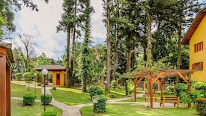 A garden area with pathways, benches, and a pergola structure. - LOCAR-IN GRAMADO- Vista do Quilombo (Gramado)