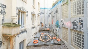 Un callejón estrecho con grafitis en las paredes y una plataforma improvisada con chalecos salvavidas anaranjados.