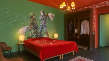 Un dormitorio con cama, una silla, un armario y un mural en la pared.