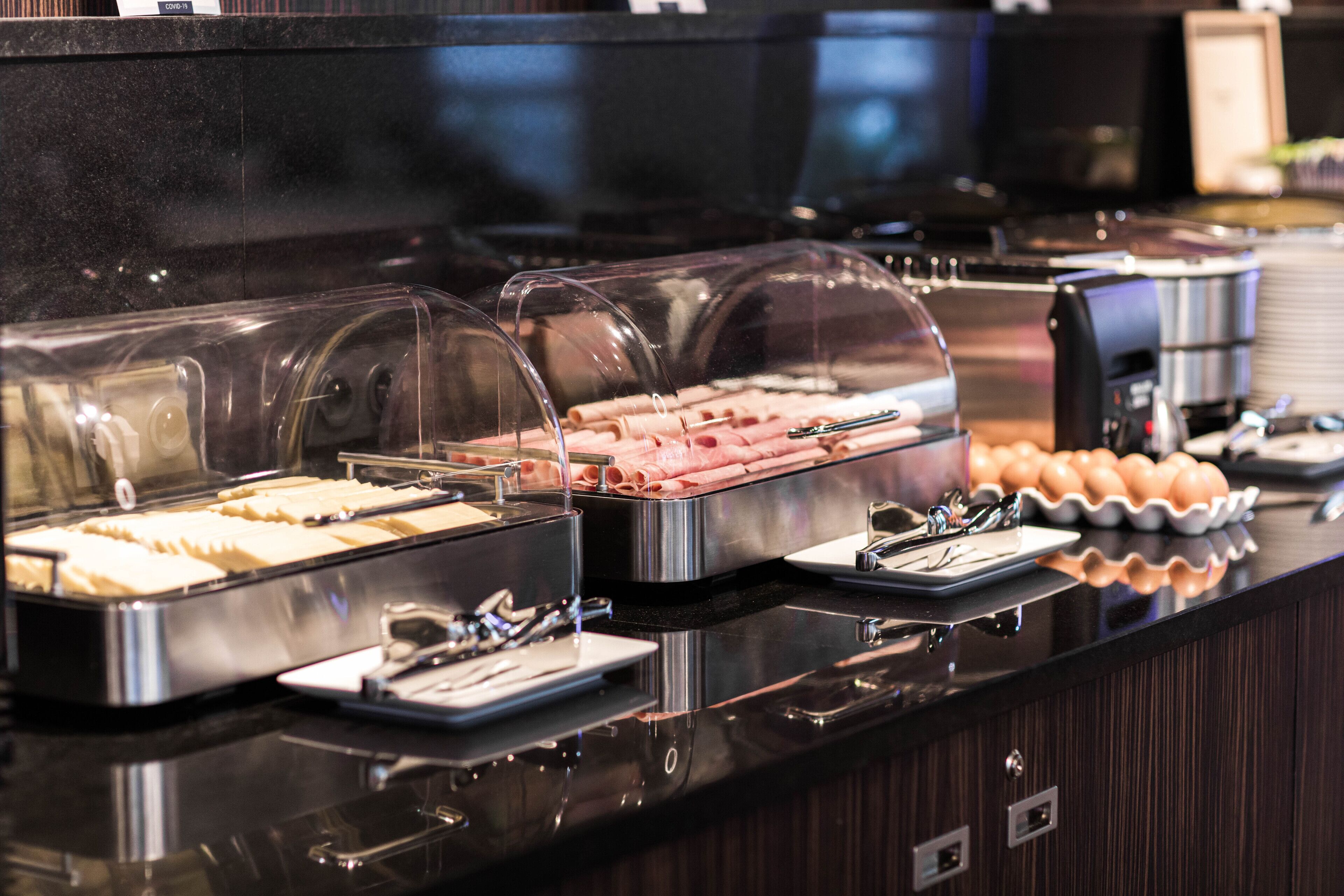 Un buffet proposant une variété de plats présentés sous des cloches transparentes.