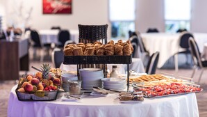 Een buffet met verschillende soorten eten, zoals fruit, gebak en snacks.