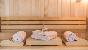 Un banc en bois, avec des serviettes et une pile de pierres.